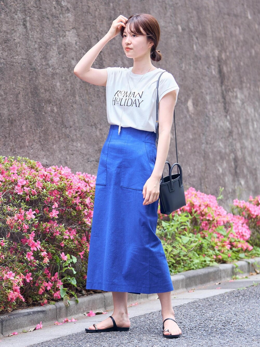 グレー系のショルダーバッグ、ブラック系のサンダル、ブルー系のスカートを着用したレディースの夏コーディネートの1枚目の写真