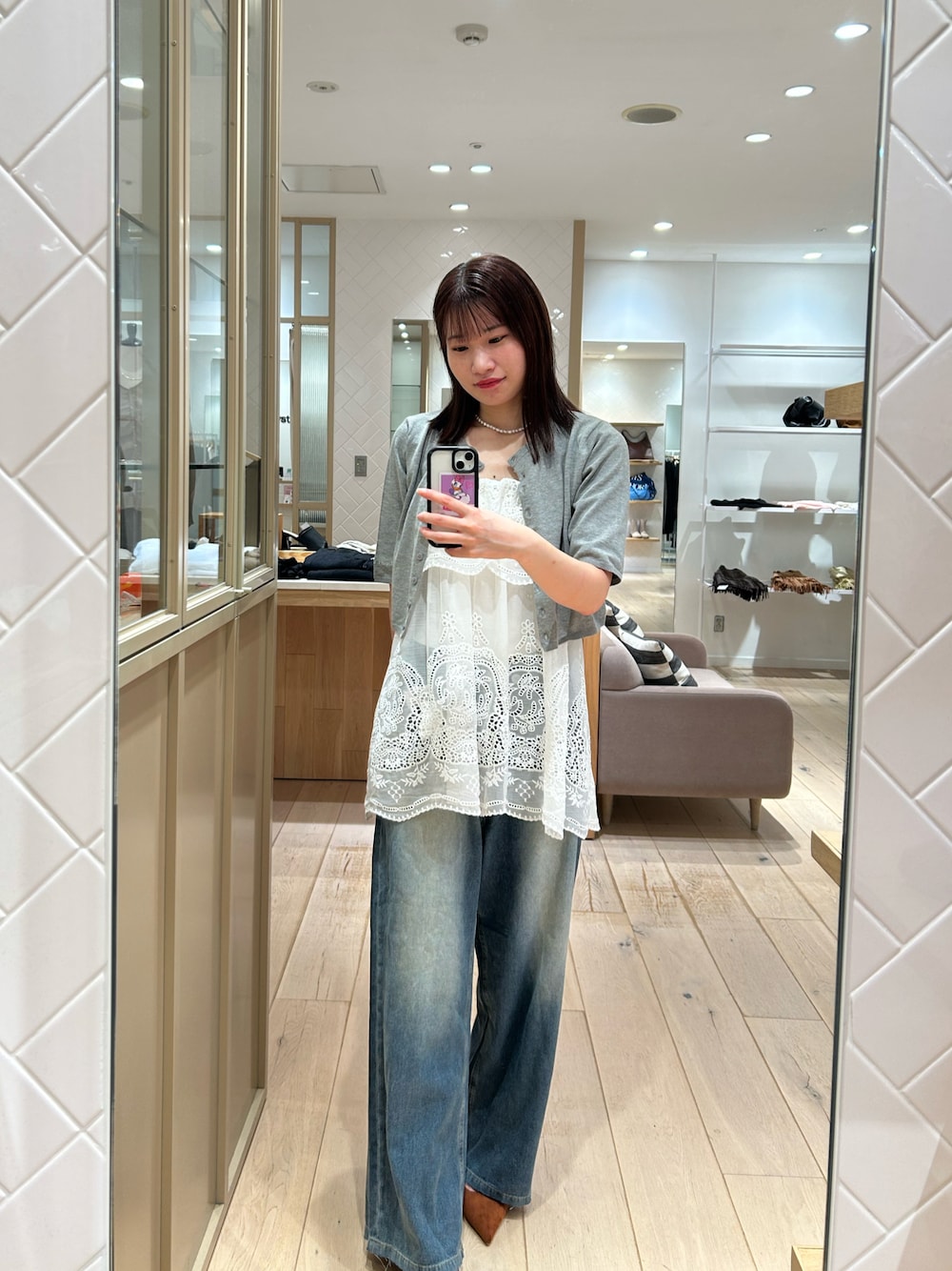 ホワイト系のシャツ/ブラウス、グレー系のカーディガン/ボレロ、ブルー系のデニムパンツを着用したレディースの秋コーディネートの1枚目の写真