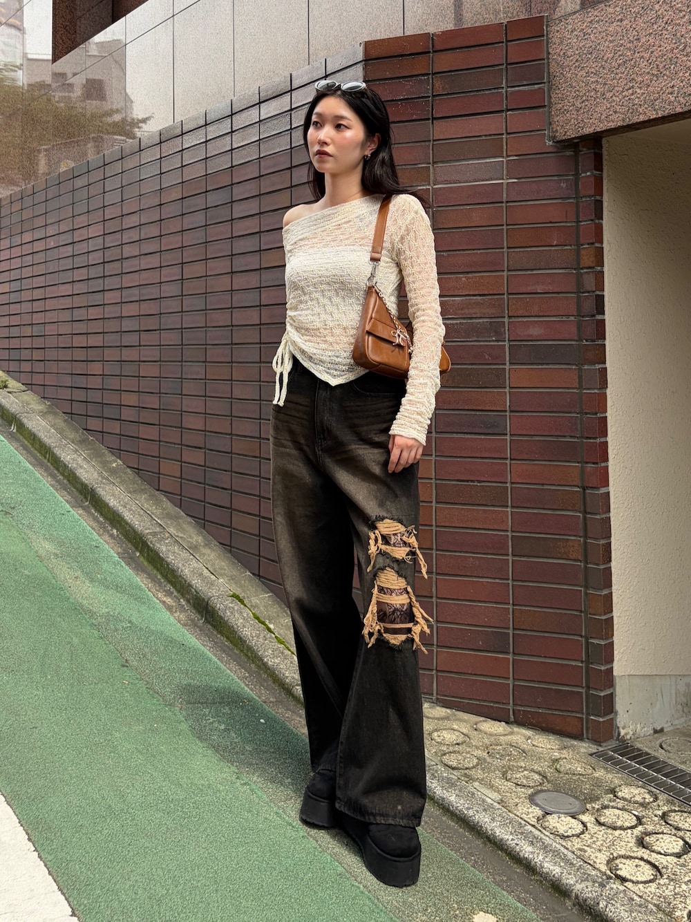 ブラウン系のショルダーバッグ、ホワイト系のTシャツ/カットソー、ブラック系のデニムパンツを着用したレディースの秋コーディネートの1枚目の写真