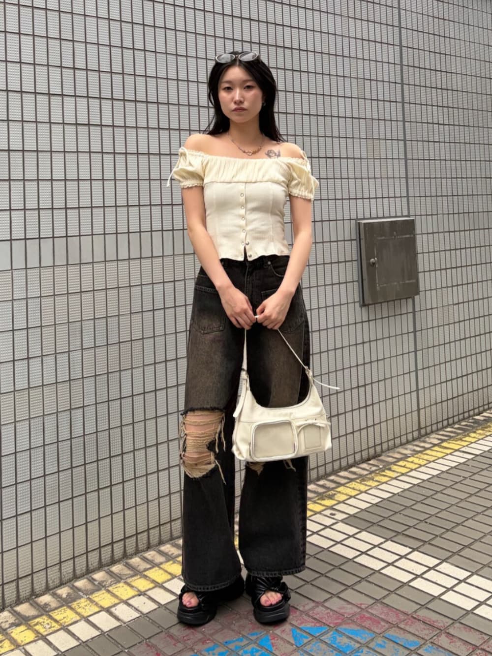ブラック系のサンダル、ホワイト系のハンドバッグ、ホワイト系のTシャツ/カットソーを着用したレディースの夏コーディネートの1枚目の写真