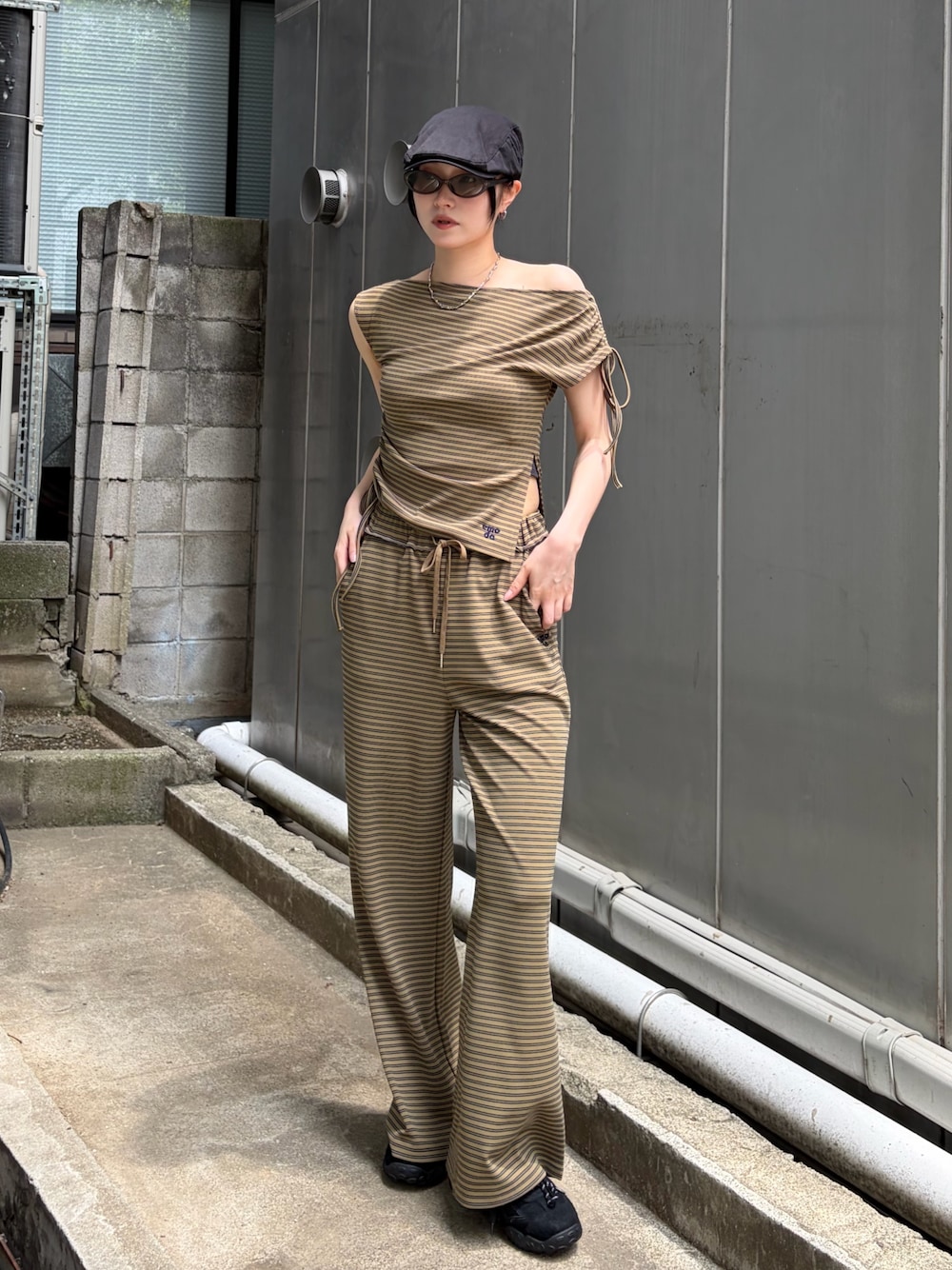 グリーン系のTシャツ/カットソー、グリーン系のその他パンツ、ブラック系のスニーカーを着用したレディースの夏コーディネートの1枚目の写真