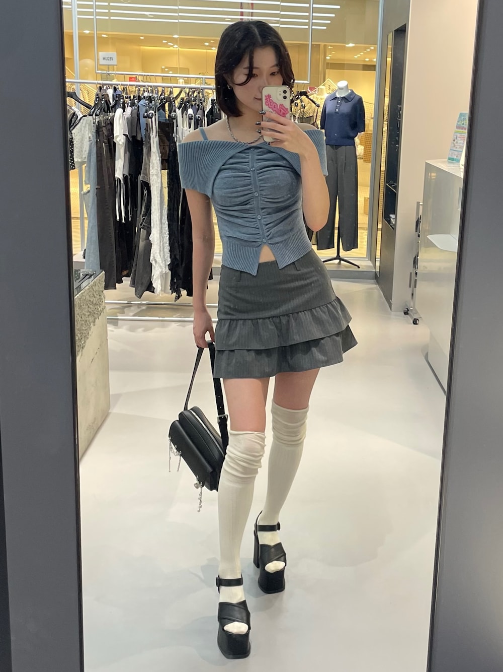 ブルー系のニット/セーター、グレー系のスカート、ブラック系のサンダルを着用したレディースの夏コーディネートの1枚目の写真