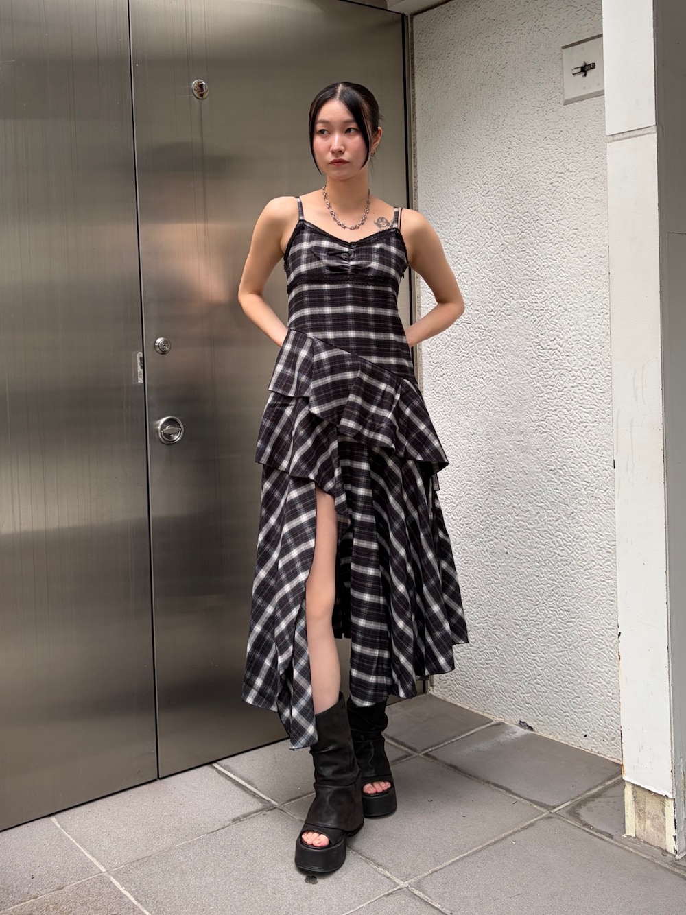 ブラック系のワンピース、ブラック系のサンダル、シルバー系のピアス(両耳用)を着用したレディースの夏コーディネートの1枚目の写真