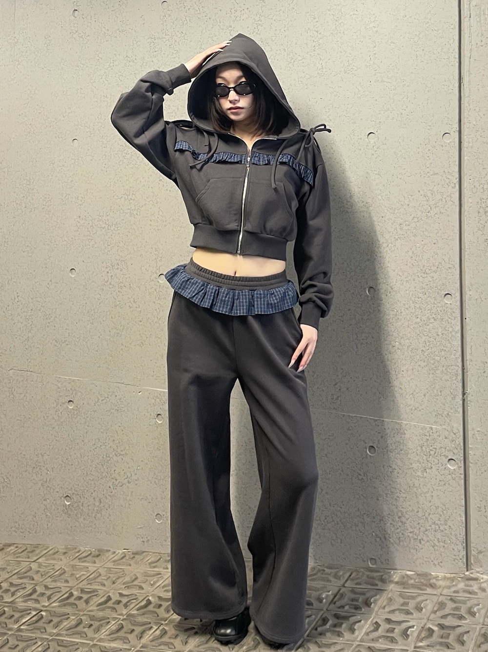 グレー系のパーカー、グレー系のスウェットパンツ、ブラック系のスニーカーを着用したレディースの冬コーディネートの1枚目の写真