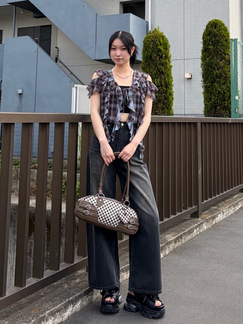 ブラック系のキャミソール、ブラウン系のTシャツ/カットソー、ブラウン系のハンドバッグを着用したレディースの春コーディネートの1枚目の写真