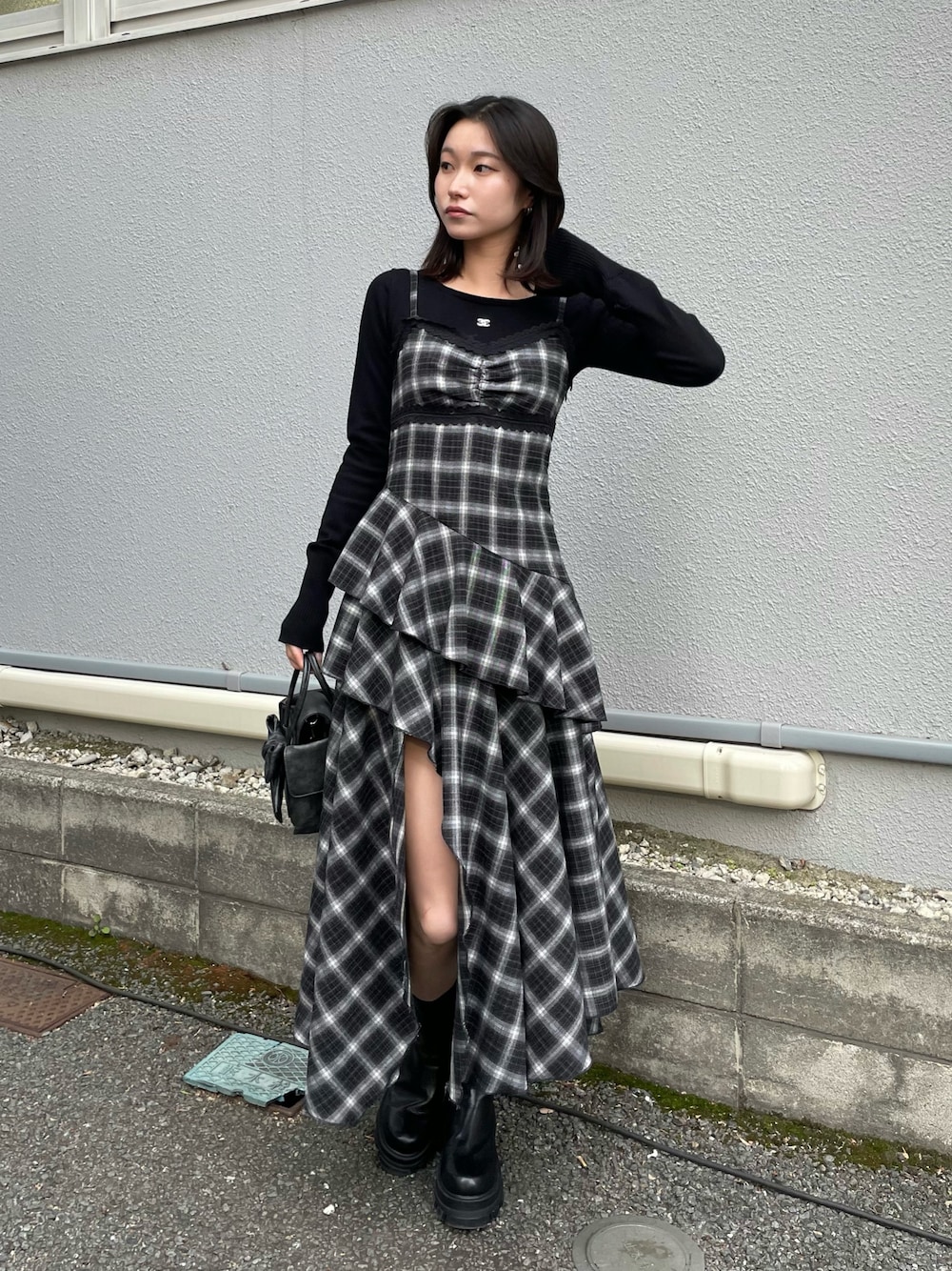 ブラック系のニット/セーター、ブラック系のワンピース、ブラック系のハンドバッグを着用したレディースの冬コーディネートの1枚目の写真