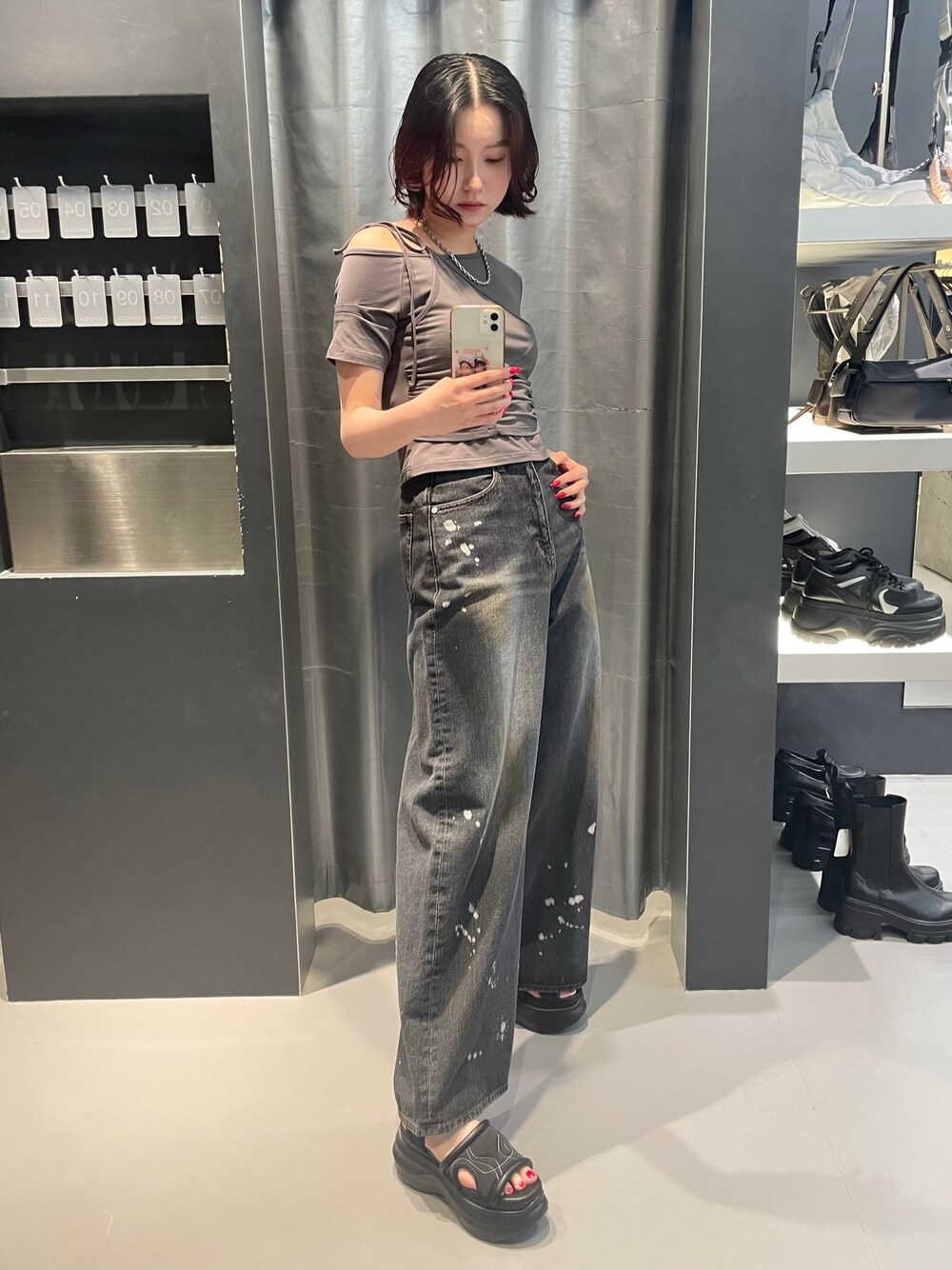 グレー系のTシャツ/カットソー、ブラック系のデニムパンツ、ブラック系のサンダルを着用したレディースの春コーディネートの1枚目の写真