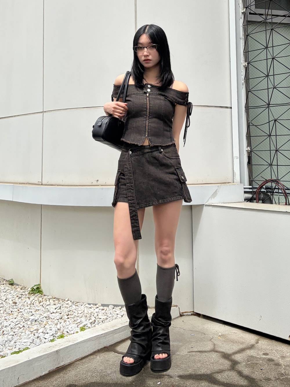 ブラック系のハンドバッグ、ブラウン系のTシャツ/カットソー、ブラウン系のスカートを着用したレディースの春コーディネートの1枚目の写真
