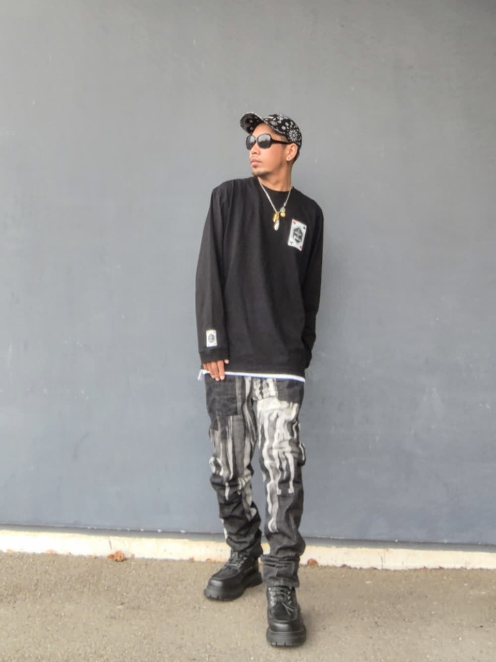 ブラック系のTシャツ/カットソー、ホワイト系のタンクトップ、ブラック系のデニムパンツを着用したメンズの春コーディネートの1枚目の写真