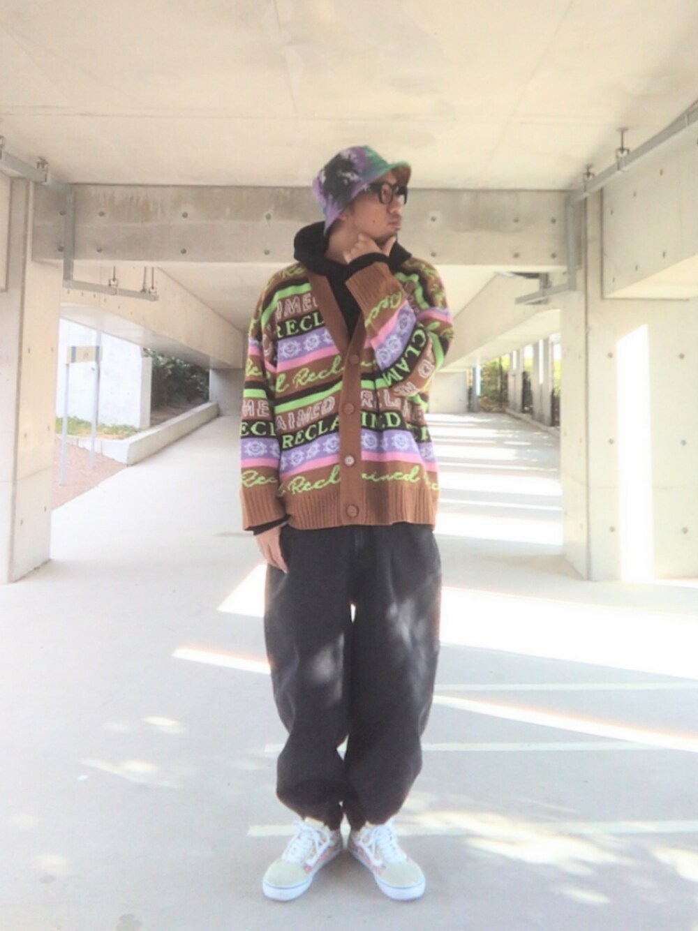 ブラック系のパーカー、ブラウン系のカーディガン/ボレロ、ブラック系のデニムパンツを着用したメンズの冬コーディネートの1枚目の写真