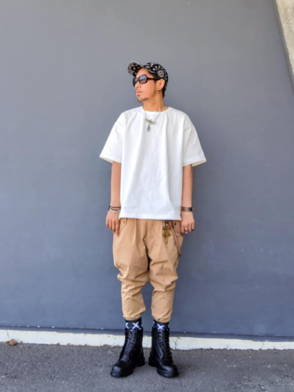 ホワイト系のTシャツ/カットソー、ベージュ系のその他パンツ、ブラック系のブーツを着用したメンズの春コーディネートの1枚目の写真