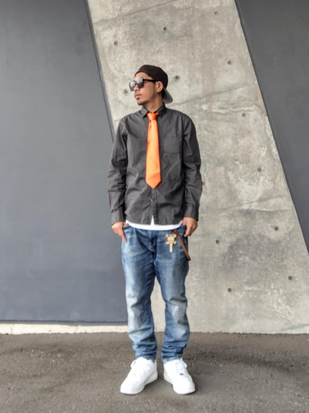 オレンジ系のネクタイ、ブラック系のシャツ/ブラウス、ブルー系のデニムパンツを着用したメンズの春コーディネートの1枚目の写真