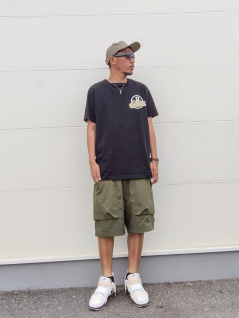 ブラック系のTシャツ/カットソー、グリーン系のその他パンツ、ブラウン系のスニーカーを着用したメンズの夏コーディネートの1枚目の写真