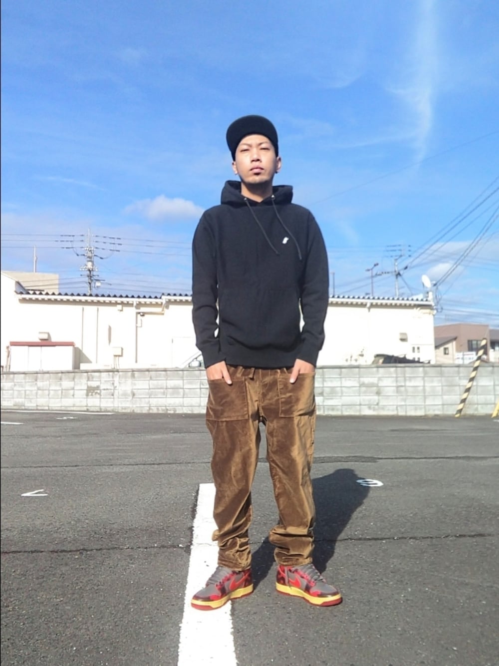 ブラウン系のその他パンツ、ブラック系のパーカー、グレー系のスニーカーを着用したメンズの冬コーディネートの1枚目の写真