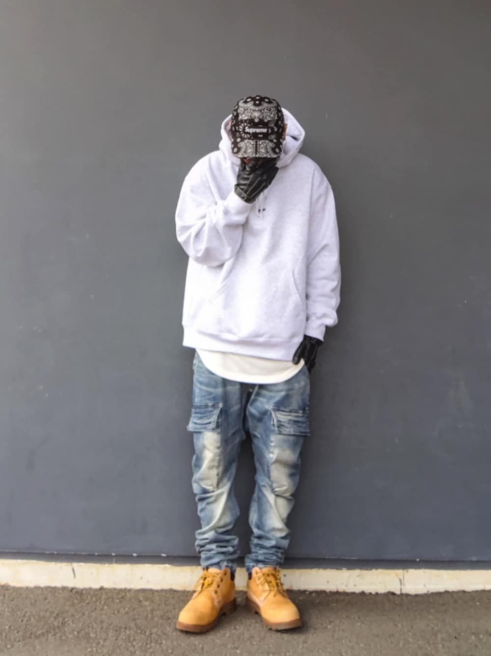 グレー系のパーカー、ホワイト系のタンクトップ、ブルー系のデニムパンツを着用したメンズの冬コーディネートの1枚目の写真