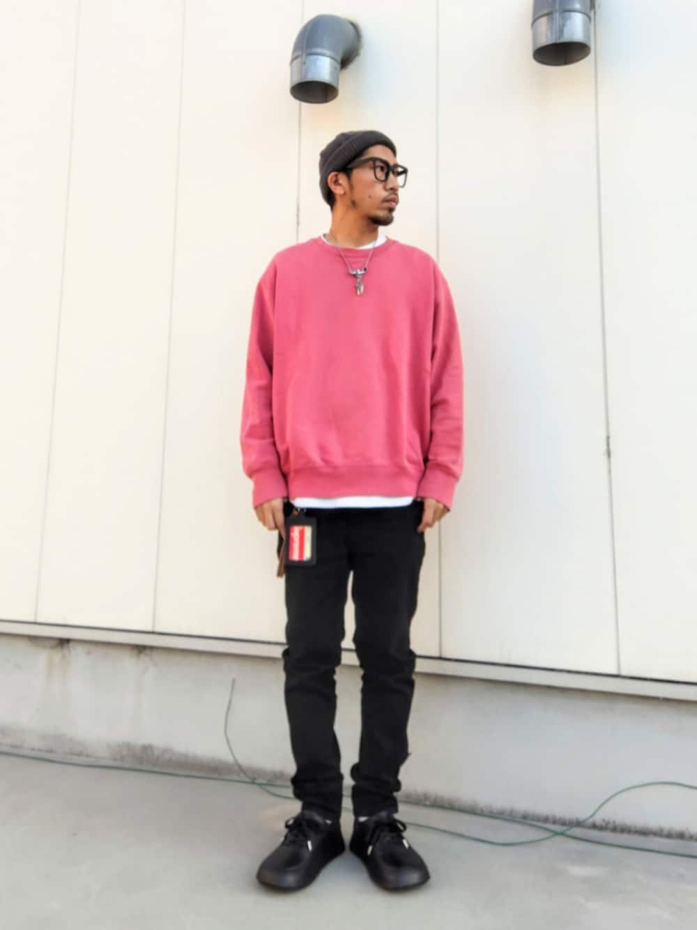 ピンク系のスウェット、ブラック系のデニムパンツ、ブラック系のスニーカーを着用したメンズの冬コーディネートの1枚目の写真