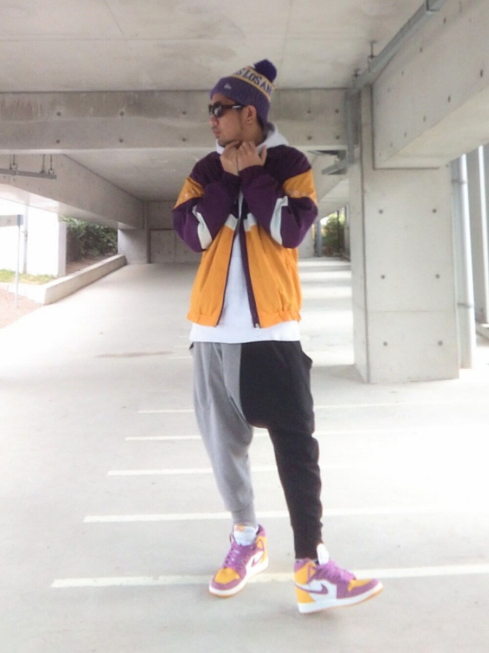 ホワイト系のパーカー、パープル系のナイロンジャケット、その他のスウェットパンツを着用したメンズの冬コーディネートの1枚目の写真