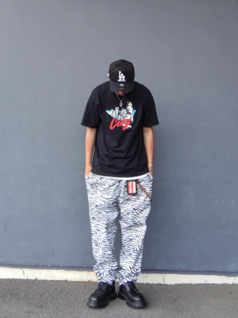 ブラック系のTシャツ/カットソー、ホワイト系のその他パンツ、ブラック系のモカシン/デッキシューズを着用したメンズの夏コーディネートの1枚目の写真