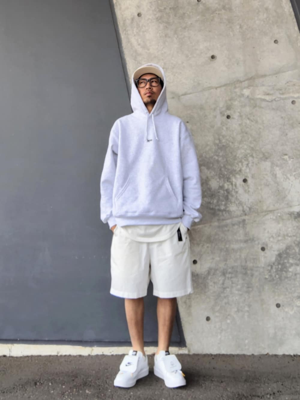 グレー系のパーカー、ホワイト系のタンクトップ、ホワイト系のその他パンツを着用したメンズの春コーディネートの1枚目の写真