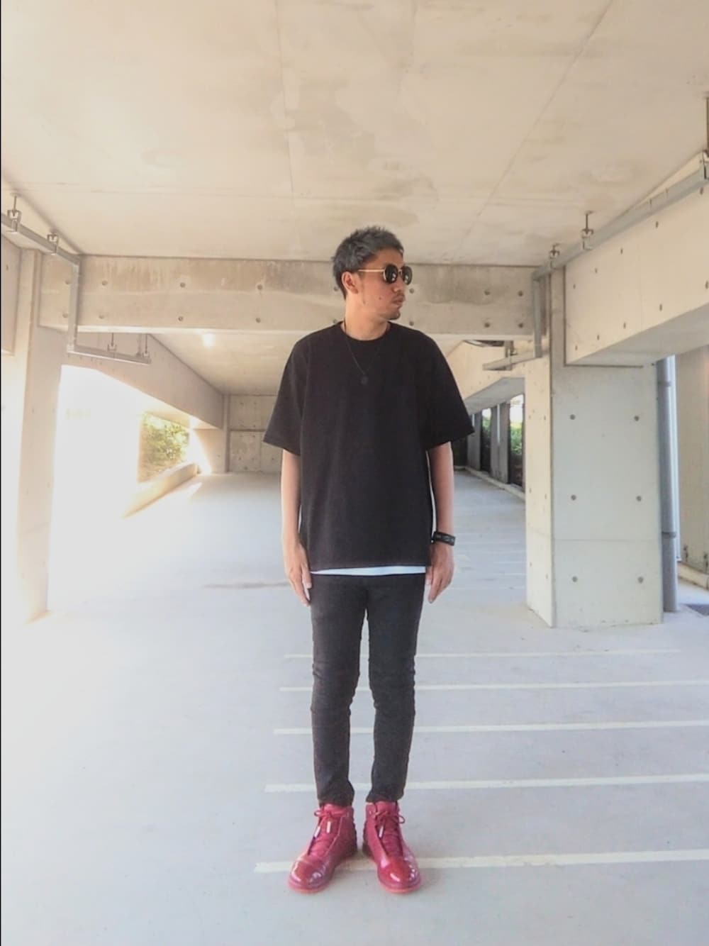 ブラック系のTシャツ/カットソー、ブラック系のデニムパンツ、レッド系のスニーカーを着用したメンズの夏コーディネートの1枚目の写真