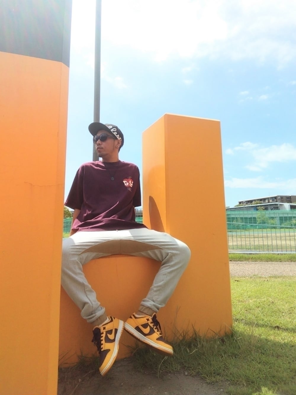 ブラウン系のTシャツ/カットソー、グレー系のスウェットパンツ、イエロー系のスニーカーを着用したメンズの夏コーディネートの1枚目の写真