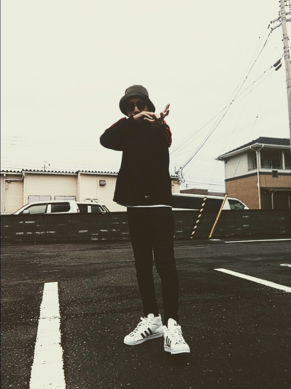 ブラック系のジャージ、ブルー系のデニムパンツ、ホワイト系のスニーカーを着用したメンズの冬コーディネートの1枚目の写真