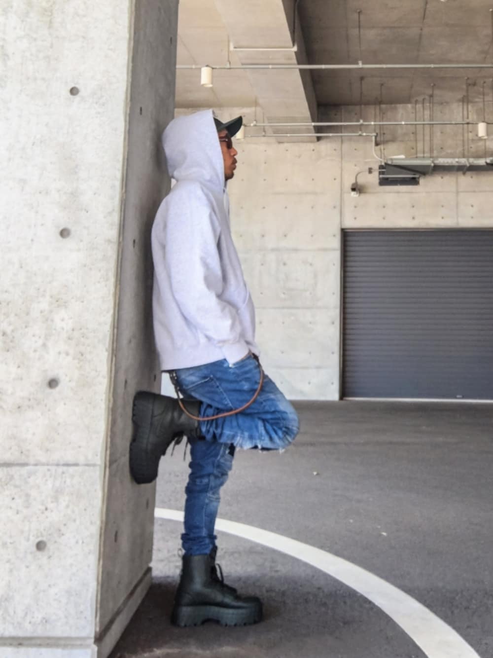 グレー系のパーカー、ブルー系のデニムパンツ、グリーン系のスニーカーを着用したメンズの冬コーディネートの1枚目の写真