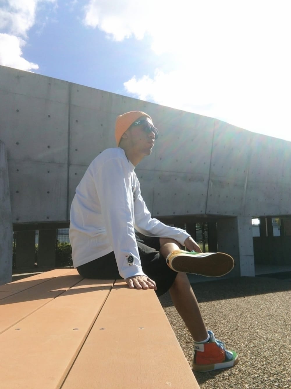 ホワイト系のTシャツ/カットソー、ブラック系のその他パンツ、オレンジ系のスニーカーを着用したメンズの秋コーディネートの1枚目の写真