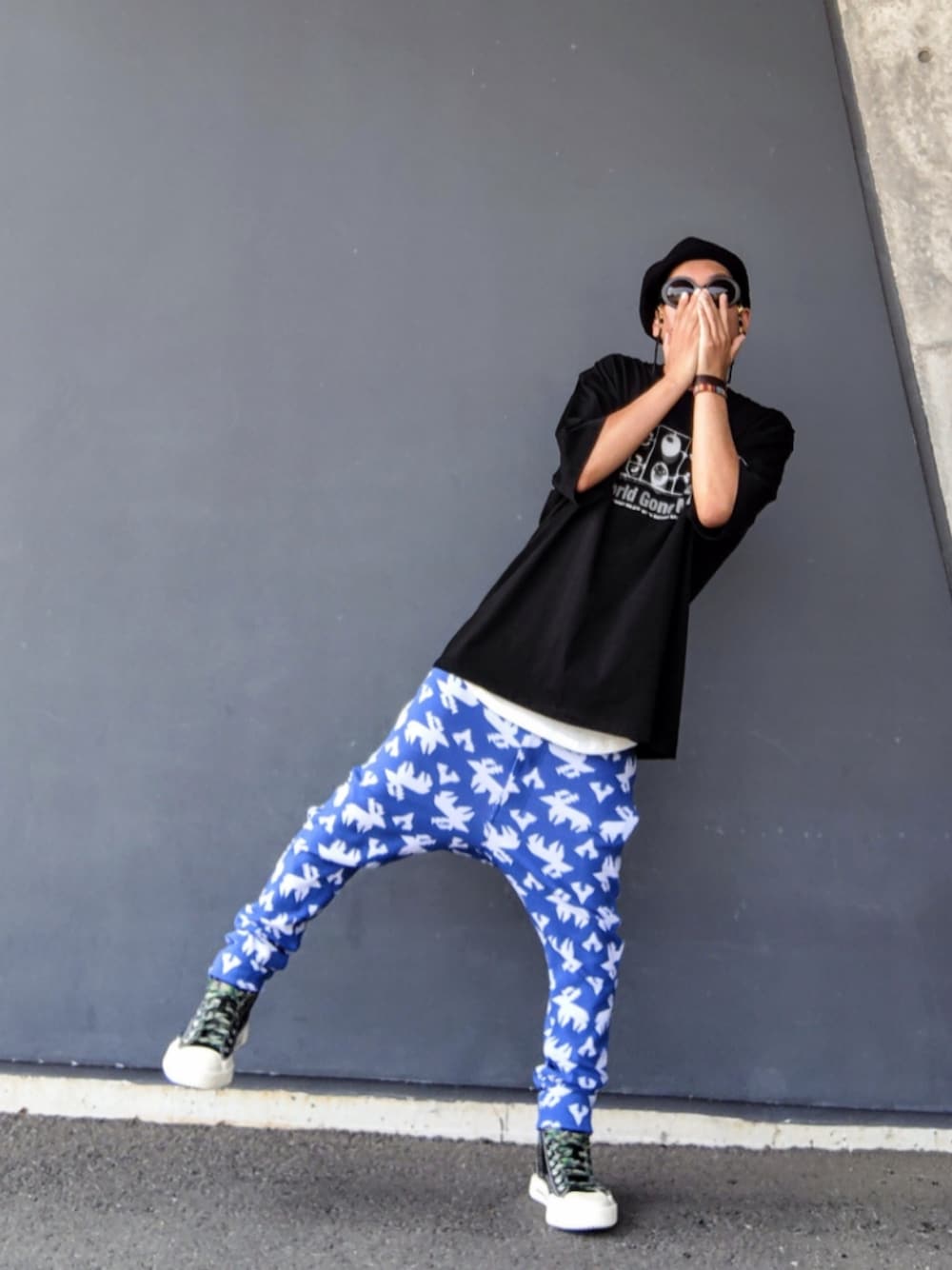 ブラック系のTシャツ/カットソー、ブルー系のその他パンツ、ブラック系のスニーカーを着用したメンズの夏コーディネートの1枚目の写真