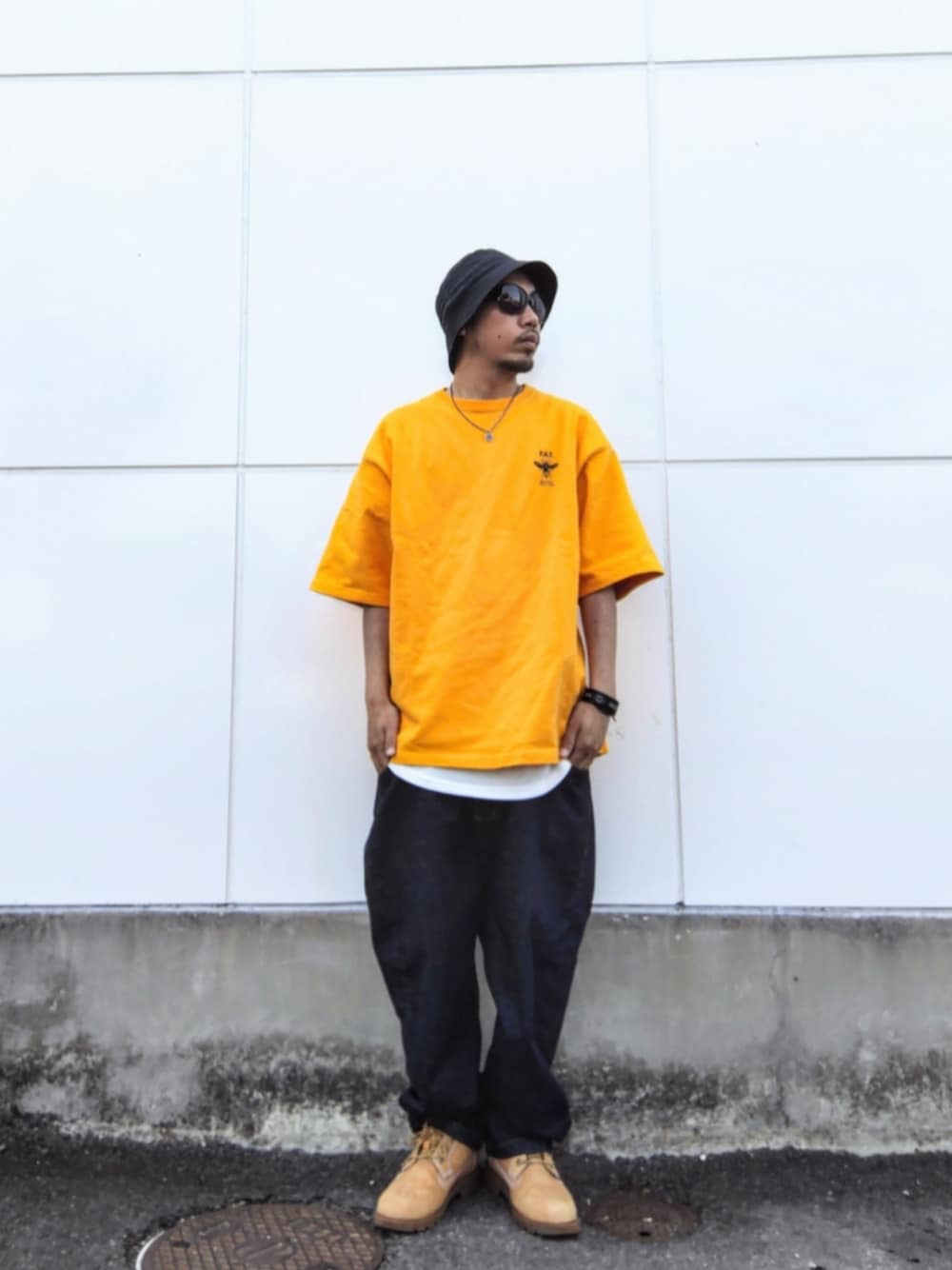 イエロー系のTシャツ/カットソー、ブルー系のデニムパンツ、イエロー系のブーツを着用したメンズの春コーディネートの1枚目の写真