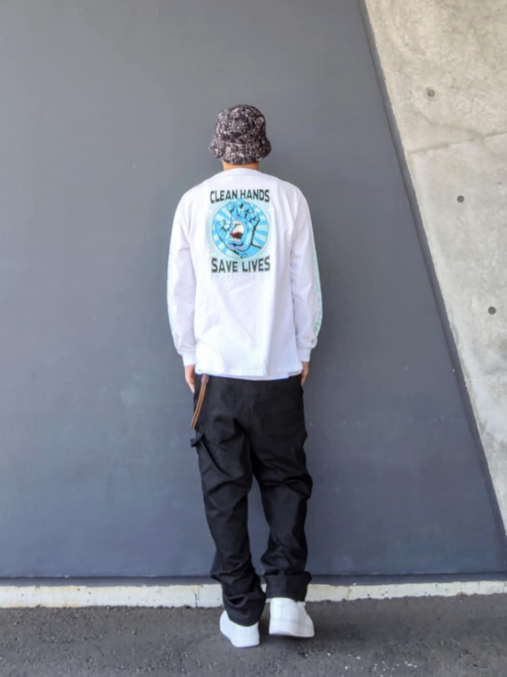 ホワイト系のTシャツ/カットソー、ブラック系のデニムパンツ、ホワイト系のスニーカーを着用したメンズの春コーディネートの1枚目の写真