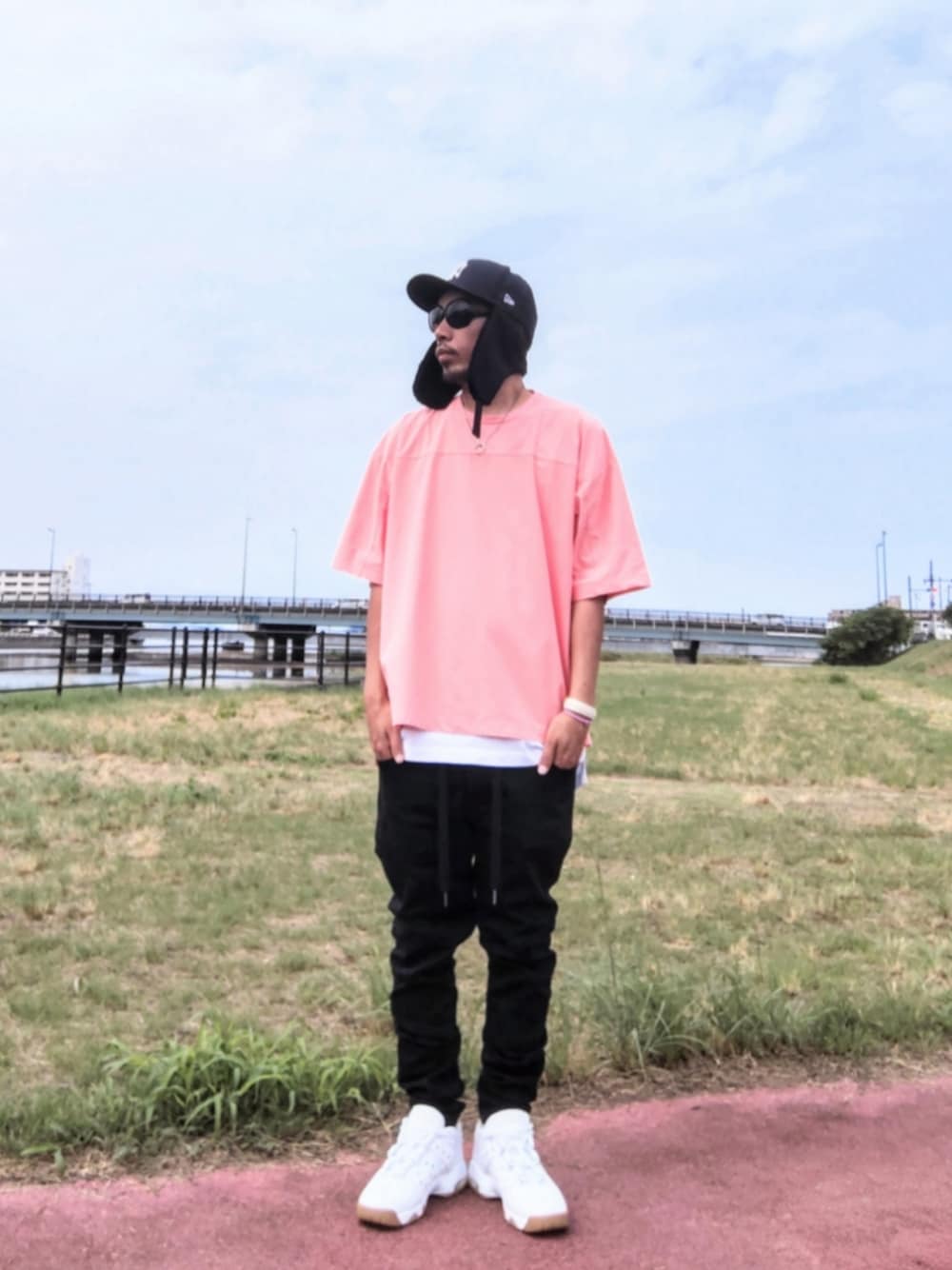 ピンク系のTシャツ/カットソー、ホワイト系のタンクトップ、ブラック系のデニムパンツを着用したメンズの秋コーディネートの1枚目の写真