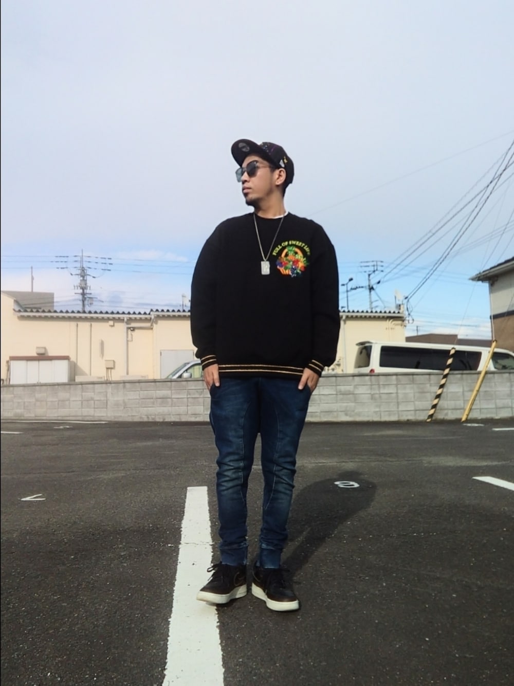 ブラック系のスウェット、ブラック系のスニーカー、ブルー系のパンツを着用したメンズの冬コーディネートの1枚目の写真