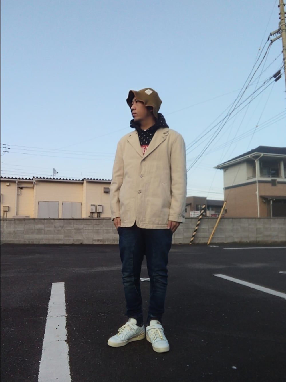 ベージュ系のデニムジャケット、ブルー系のパンツ、ブラック系のパーカーを着用したメンズの冬コーディネートの1枚目の写真