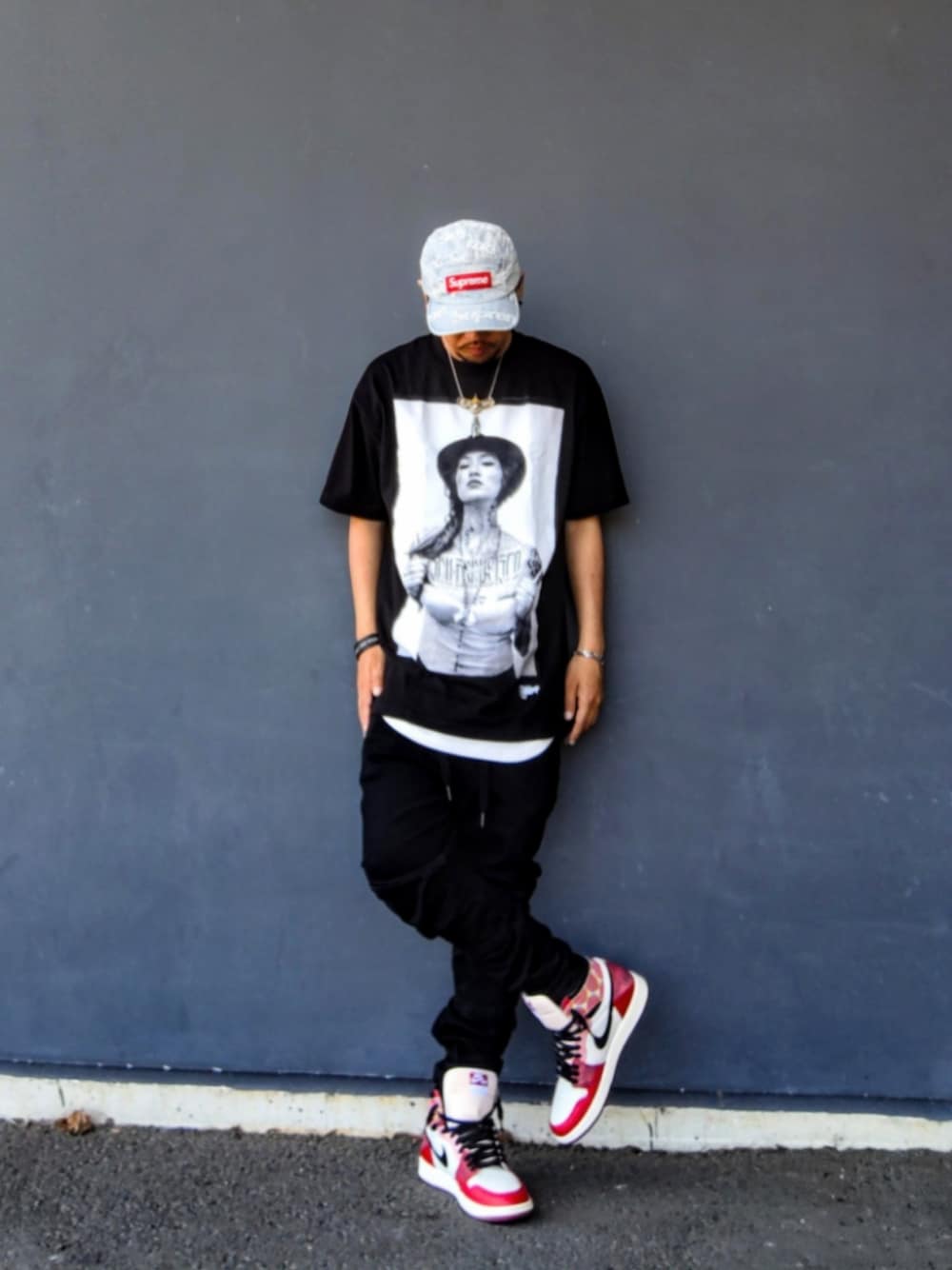 ブラック系のTシャツ/カットソー、ブラック系のデニムパンツ、レッド系のスニーカーを着用したメンズの春コーディネートの1枚目の写真