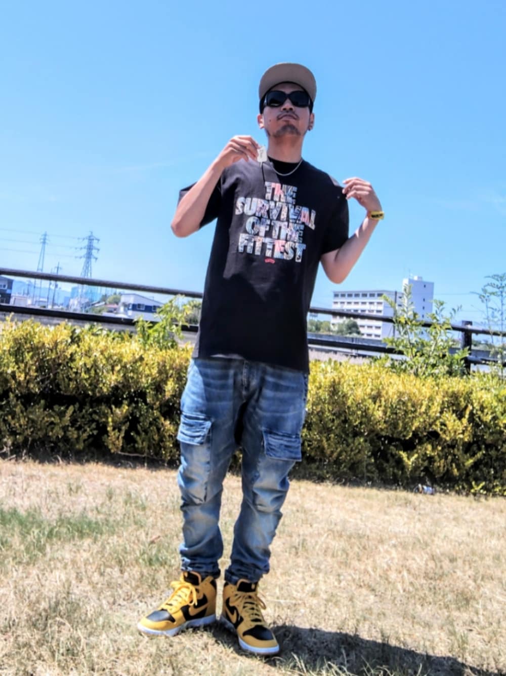 ブラック系のTシャツ/カットソー、ブルー系のデニムパンツ、イエロー系のスニーカーを着用したメンズの夏コーディネートの1枚目の写真