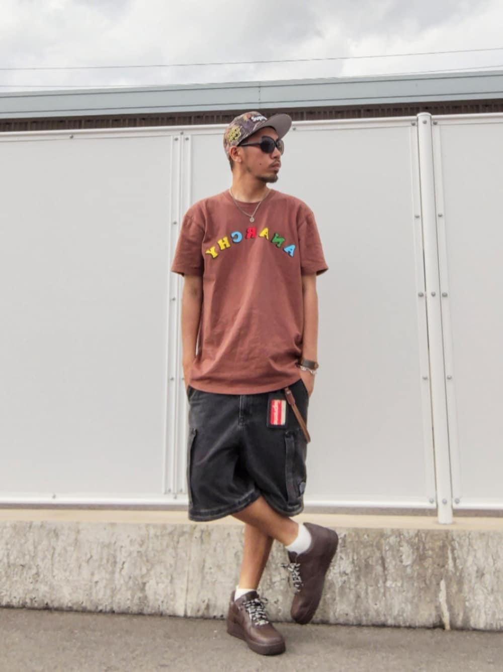 ブラウン系のTシャツ/カットソー、ブラック系のその他パンツ、ブラウン系のスニーカーを着用したメンズの夏コーディネートの1枚目の写真