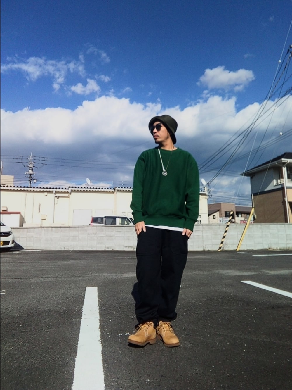 グリーン系のスウェット、ブラック系のスウェットパンツ、イエロー系のブーツを着用したメンズの冬コーディネートの1枚目の写真