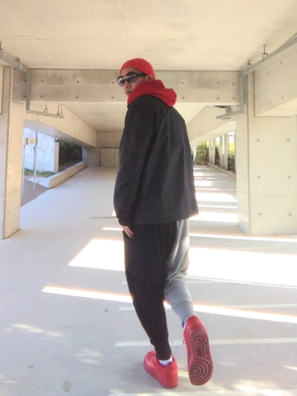 レッド系のパーカー、ブルー系のナイロンジャケット、その他のスウェットパンツを着用したメンズの冬コーディネートの1枚目の写真