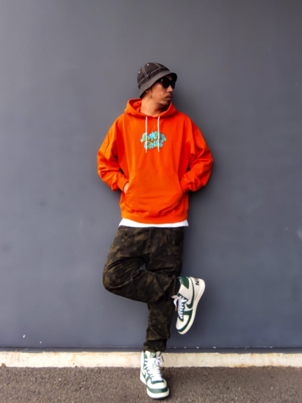 オレンジ系のパーカー、その他のパンツ、ホワイト系のスニーカーを着用したメンズの秋コーディネートの1枚目の写真