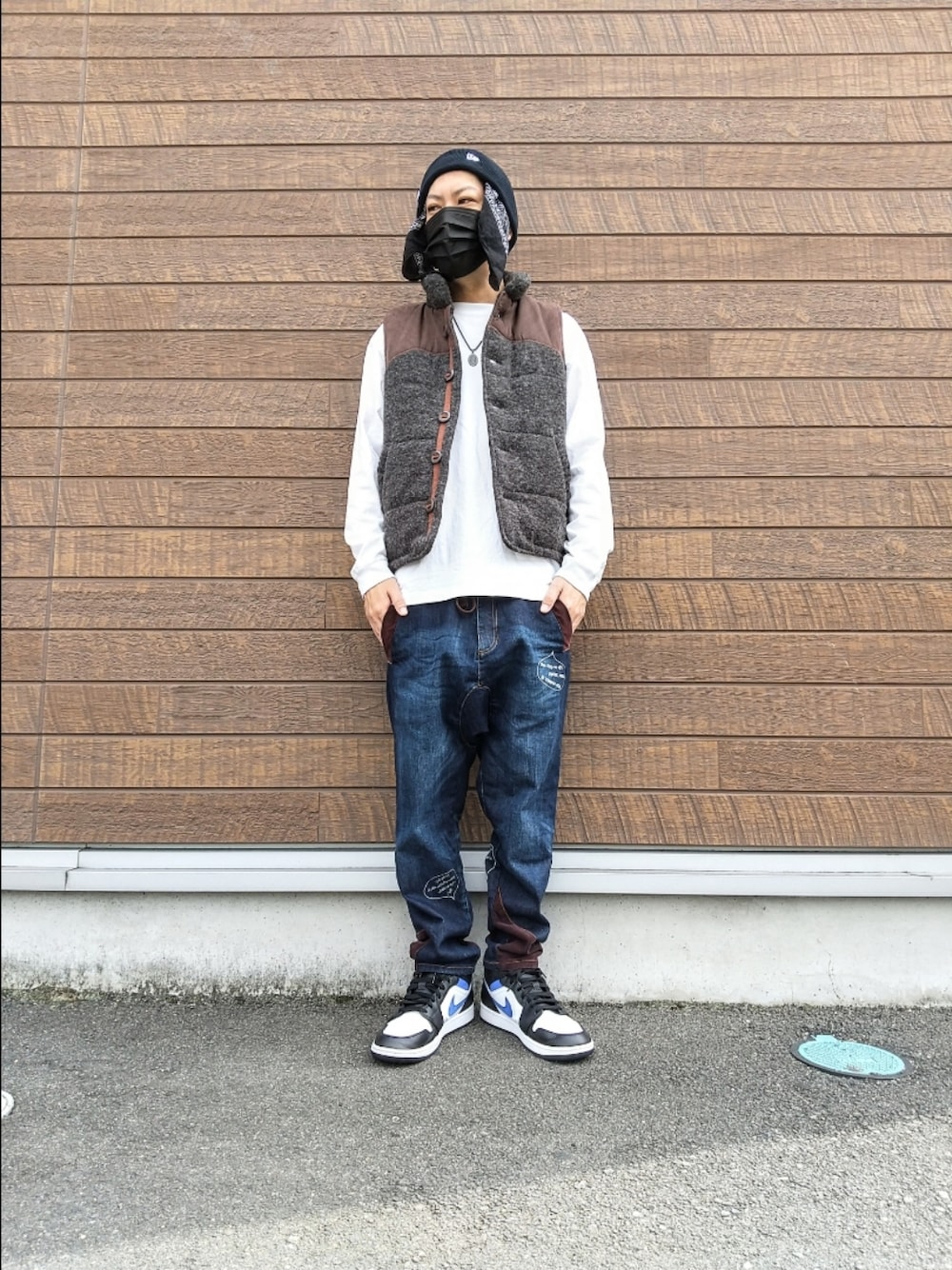 グレー系のベスト、ホワイト系のTシャツ/カットソー、ブルー系のデニムパンツを着用したメンズの秋コーディネートの1枚目の写真