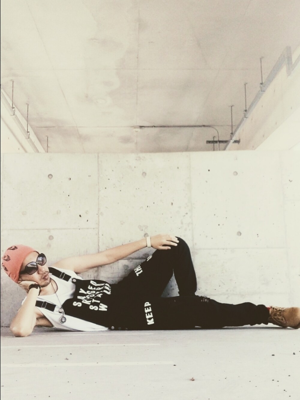 ブラック系のサロペット/オーバーオール、イエロー系のブーツ、オレンジ系のニットキャップ/ビーニーを着用したメンズの秋コーディネートの1枚目の写真