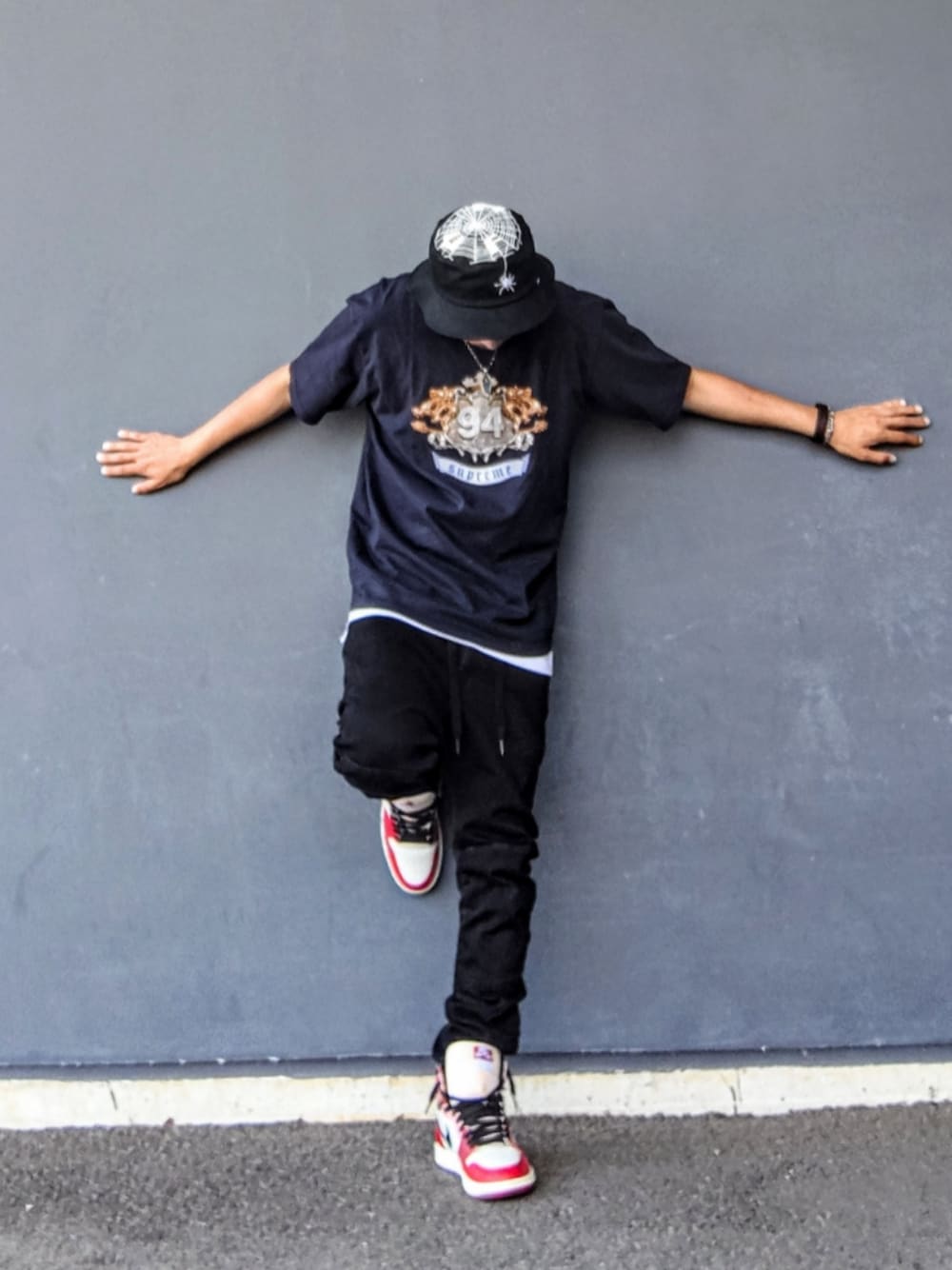 ブラック系のTシャツ/カットソー、ホワイト系のタンクトップ、ブラック系のデニムパンツを着用したメンズの夏コーディネートの1枚目の写真