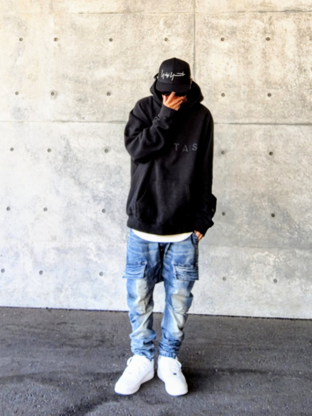 ブラック系のパーカー、ホワイト系のタンクトップ、ブルー系のデニムパンツを着用したメンズの冬コーディネートの1枚目の写真