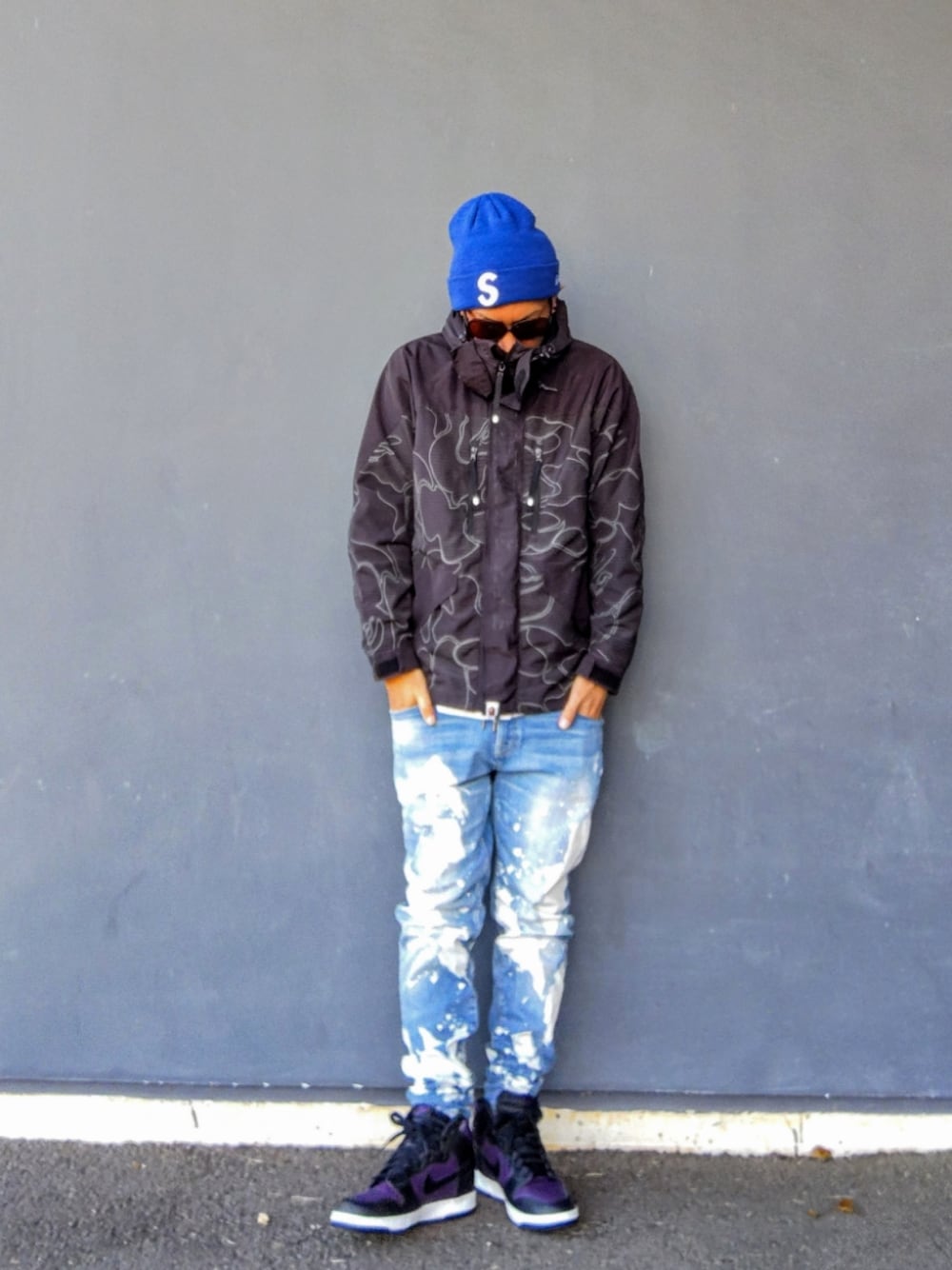 ブラック系のミリタリージャケット、ブルー系のデニムパンツ、パープル系のスニーカーを着用したメンズの冬コーディネートの1枚目の写真