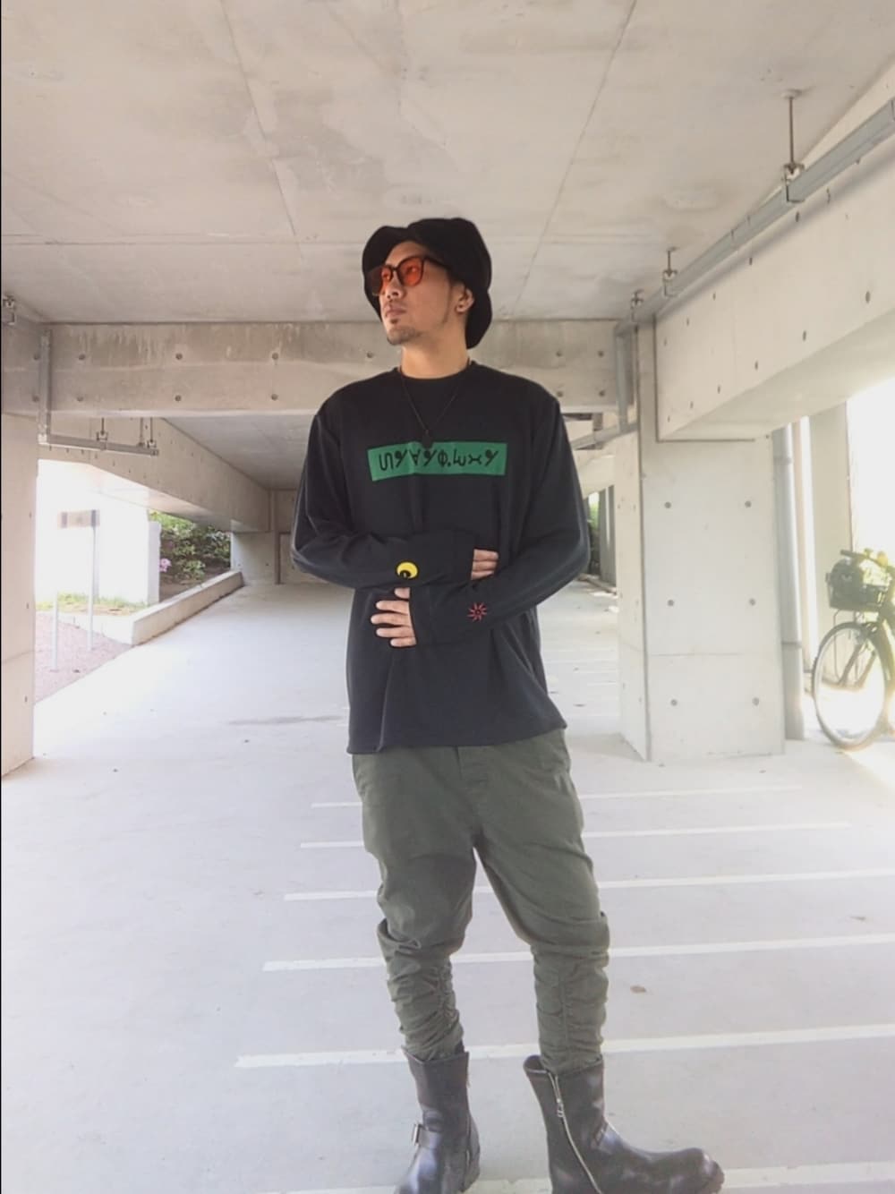ブラック系のTシャツ/カットソー、グリーン系のパンツ、ブラック系のブーツを着用したメンズの春コーディネートの1枚目の写真