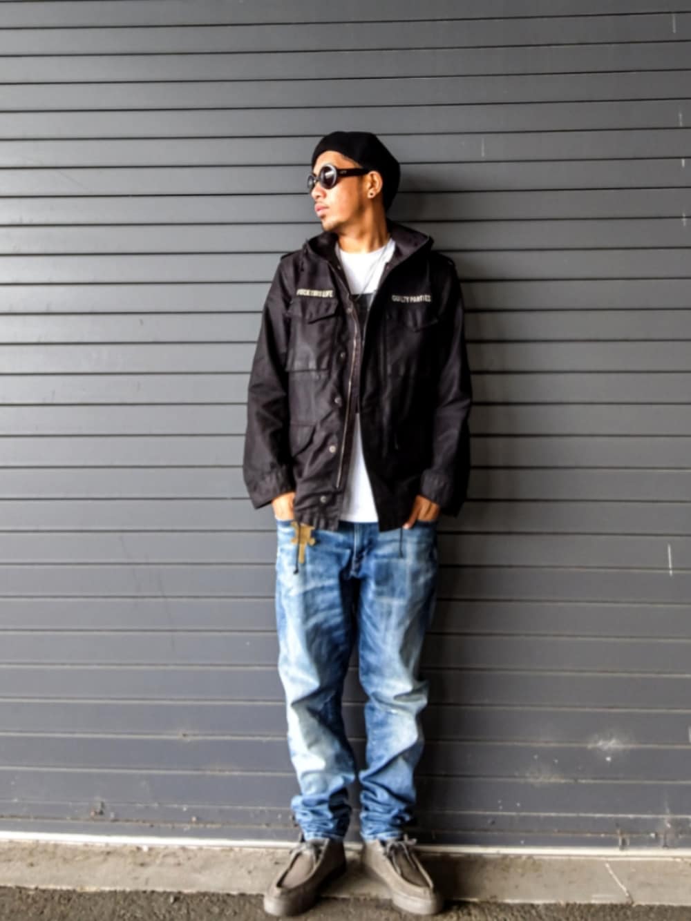 ブラック系のミリタリージャケット、ホワイト系のTシャツ/カットソー、ブルー系のデニムパンツを着用したメンズの秋コーディネートの1枚目の写真