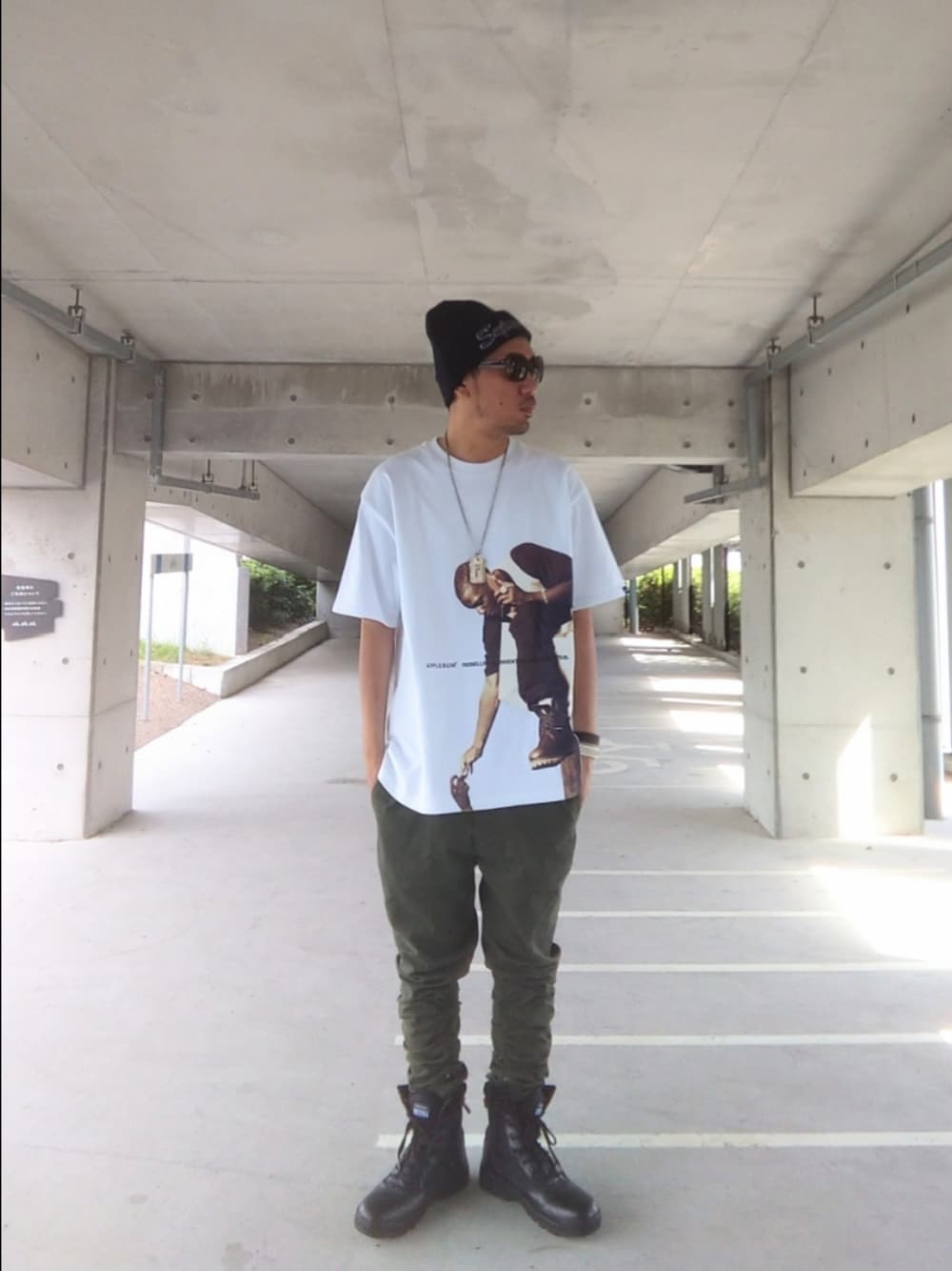 ホワイト系のTシャツ/カットソー、グリーン系のパンツ、ブラック系のブーツを着用したメンズの秋コーディネートの1枚目の写真