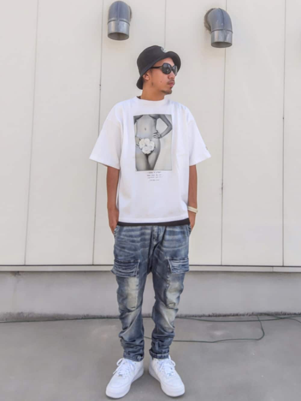 ホワイト系のTシャツ/カットソー、ブルー系のデニムパンツ、ホワイト系のスニーカーを着用したメンズの秋コーディネートの1枚目の写真