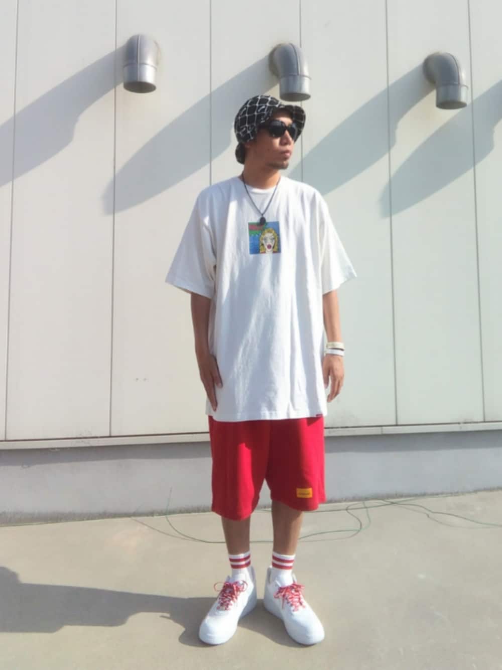 ホワイト系のTシャツ/カットソー、レッド系のその他パンツ、ホワイト系のスニーカーを着用したメンズの夏コーディネートの1枚目の写真